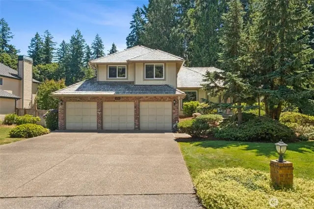 Another view of the front and driveway, with mature landscaping. The whole house has Cedar Siding, Roof is from 2006, all windows replaced 2018, Gutters 2024, AC installed in 2017 and new furnace in 2020. There's also a whole house on demand generator!