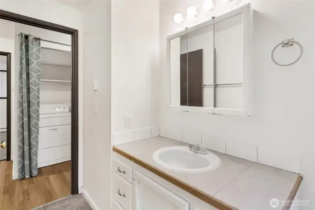 Bath opposite laundry closet.