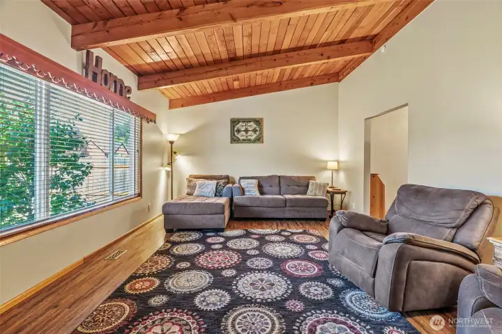Entering front door to living room with vaulted wood celilings