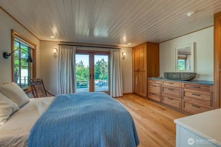 French doors off the primary bedroom lead to layered decks, a hot tub and the gardens.