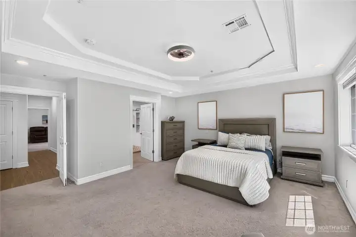 Expansive primary bedroom with tray ceiling, sitting area, and plenty of room for oversized furnishings.