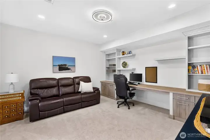 Versatile office or flex space with custom built-in desk, extensive cabinetry, and room for multiple workstations.