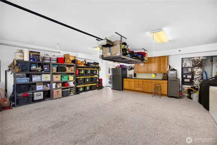 Attached two-car garage with epoxy flooring, built-in storage, and ample room for vehicles, hobbies, and gear.