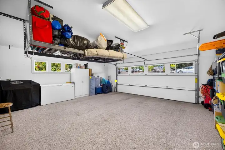 Attached two-car garage with epoxy flooring, built-in storage, and ample room for vehicles, hobbies, and gear.