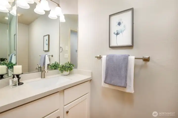 Updated & spacious powder room with marble counter & updated lighting Updated & spacious powder room with marble counter & updated lighting