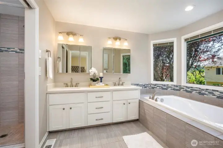 Upgraded primary bath features tile floors, large soaking tub; 2 sinks & separate shower/toilet area. Lage shower features full tile enclosure & upgraded clear door; pocket door for privacy Upgraded primary bath features tile floors, large soaking tub; 2 sinks & separate shower/toilet area. Lage shower features full tile enclosure & upgraded clear door; pocket door for privacy