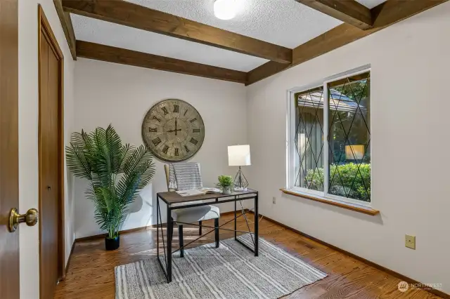Bedroom or office on main level. Original wood beams, closet to left, front yard facing windows, inspires potential for main level ensuite with (current) adjacent 1/2 bath & utility room.