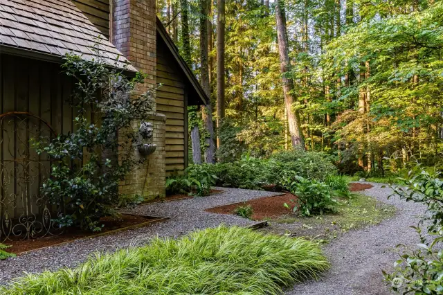 Beautiful fairytale-like setting. Gate to right side of home leads you down winding path that continues around the entire perimeter of home. Professionally landscaped in June 2024.