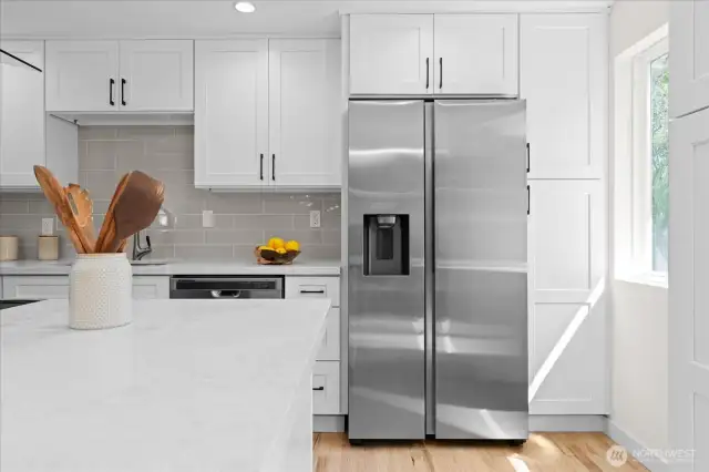 New stainless steel fridge with water dispenser, surrounded by cabinets