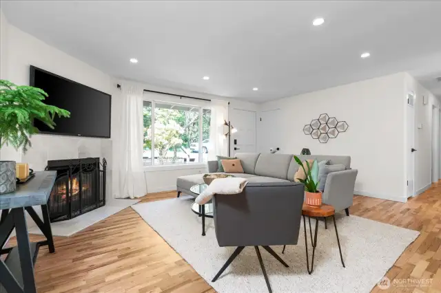 Cozy wood burning fireplace and hardwood flooring create a warm ambiance