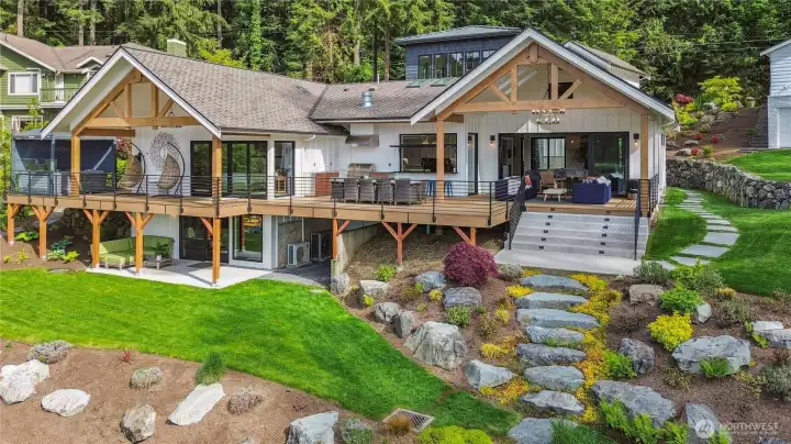 Beautiful, terraced landscaping in the backyard leading to the sandy beach.