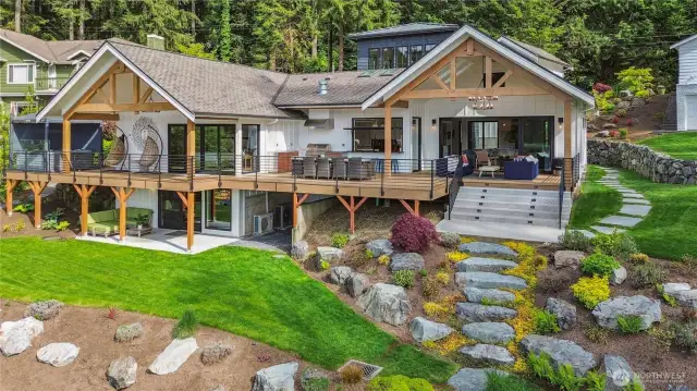 Beautiful, terraced landscaping in the backyard leading to the sandy beach.