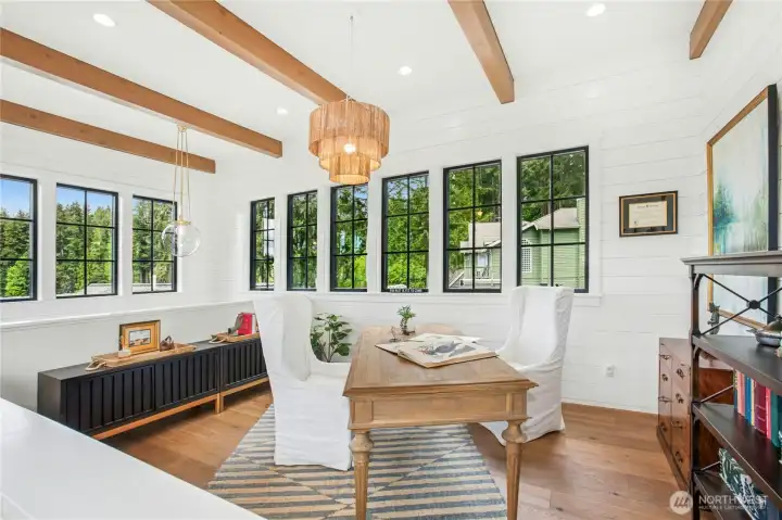 Custom exposed beams, walls of windows and incredible views highlight the home work space.