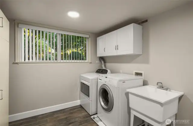 Light and bright oversized laundry with utility sink.