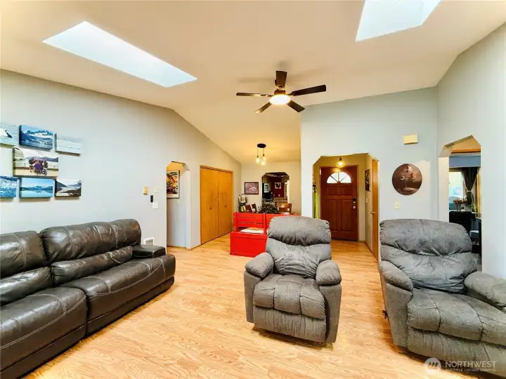 Living room, vaulted ceilings, skylights, flows into the dining area with a wall length pantry leading into the kitchen, updated lighting, LVP throughout home