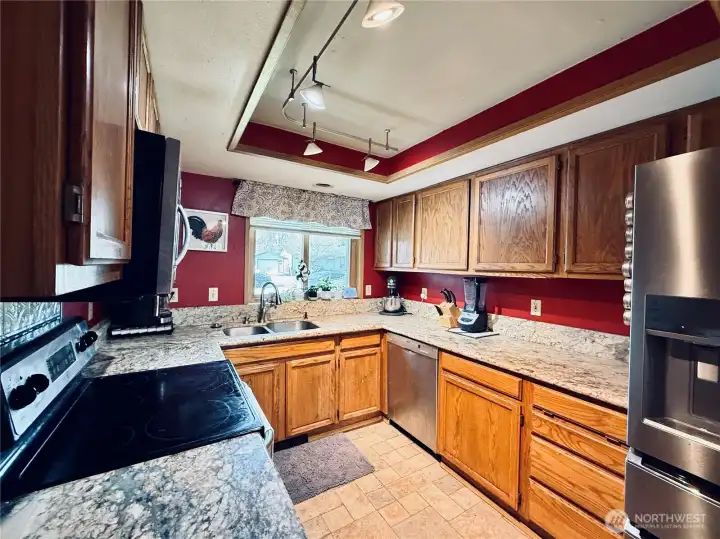Kitchen with stainless steel appliances, amply cupboards and granite countertops, LVP flooring, with updated lighting