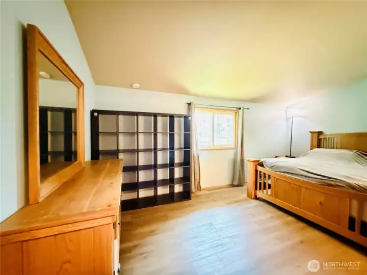 Primary suite view from the entryway, vaulted ceiling, LVP, spacious layout