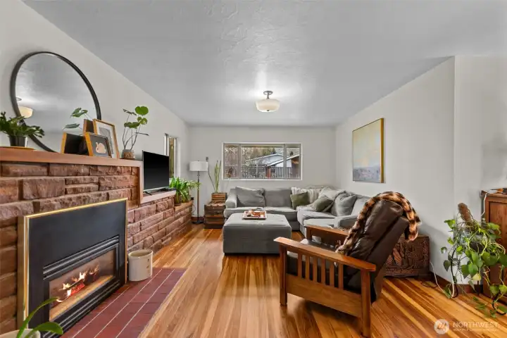 Cozy gas fireplace in the living room with the beautiful original hard wood floors