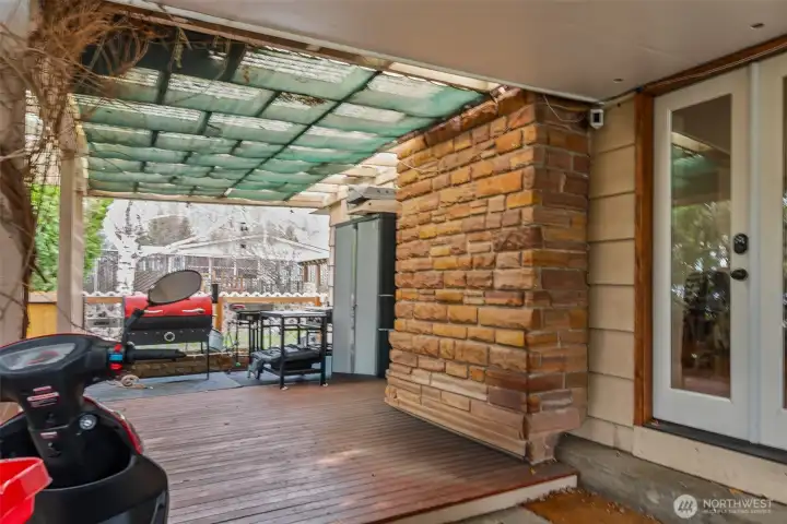 The covered patio at the end of the carport is conveniently  located off the entrance to the kitchen, perfect for all of your outdoor cooking needs.