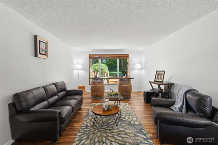 Bright and spacious living room with updated flooring and large windows that bring natural light and peaceful backyard views. Bright and spacious living room with updated flooring and large windows that bring natural light and peaceful backyard views.