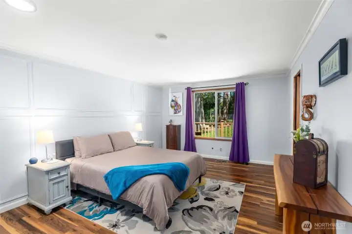 Spacious primary bedroom featuring updated flooring, abundant natural light, and serene backyard views, creating a peaceful and private retreat. Spacious primary bedroom featuring updated flooring, abundant natural light, and serene backyard views, creating a peaceful and private retreat.