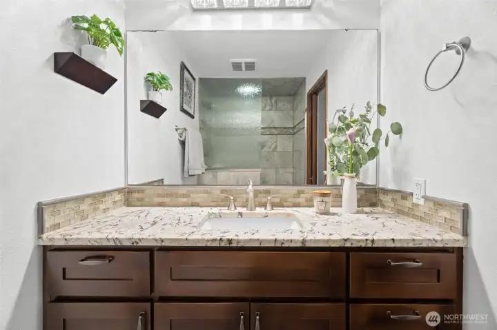 Updated en-suite bathroom featuring quartz countertops, custom cabinetry and modern finishes, offering a clean and stylish spa-like feel Updated en-suite bathroom featuring quartz countertops, custom cabinetry and modern finishes, offering a clean and stylish spa-like feel
