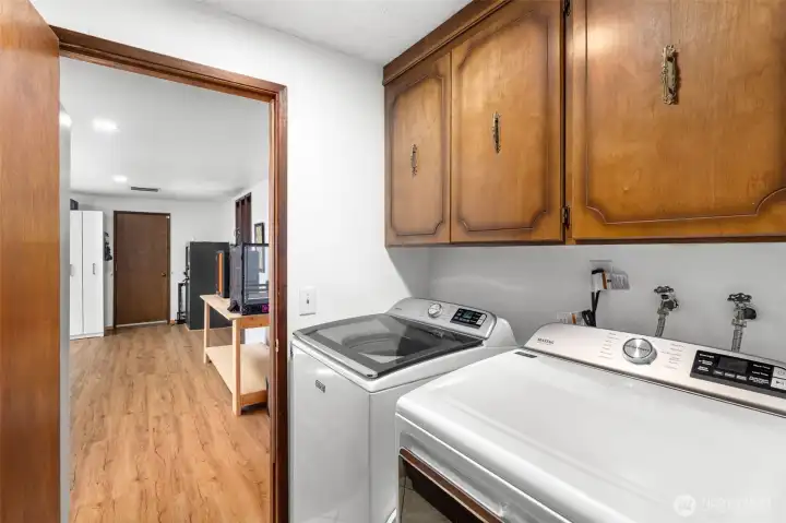 Convenient laundry area with built-in upper cabinetry for additional storage and easy access within the home's functional layout. Convenient laundry area with built-in upper cabinetry for additional storage and easy access within the home's functional layout.