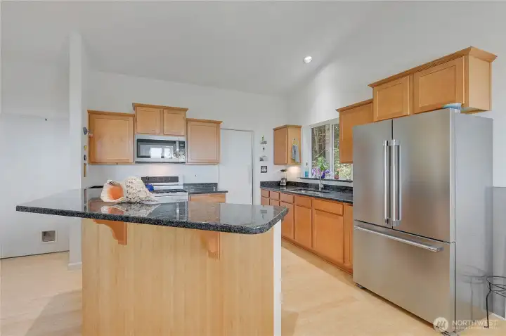 The kitchen offers ample storage space and a view of the surrounding trees.es.