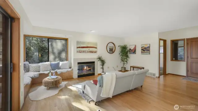 Spacious living room with wall of windows offering waves of natural light and scenic views of the lake and Mount Rainier.