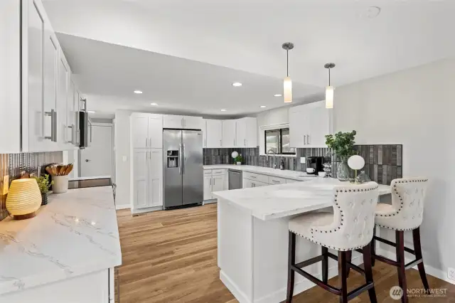 The perfect selection of quartz counter tops and stylish deco tile backsplash. Pendant lighting and an abundance of soft closing cabinetry.