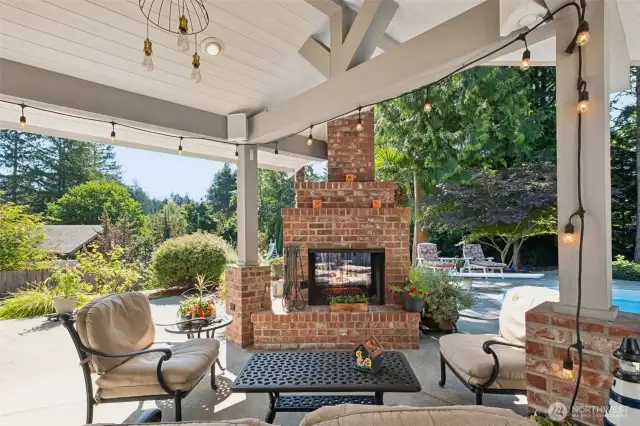 Slide out the doors to this striking covered outdoor room! Beautifully built, with high-end architectural detail, this is where we'll find you in the winter! The brick touches are just the right amount ... and you will enjoy the fireplace when the pool isn't in session!