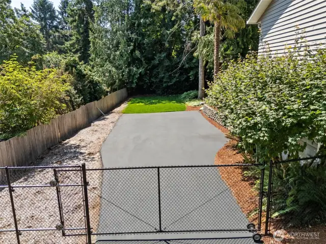 Close up of side yard to the left of the house. - Perfect spot for an RV or other rec vehicles thanks to the safety of the gate!