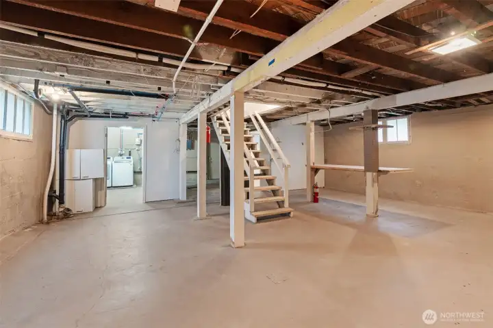 Large unfinished basement with tall ceilings and exterior exit