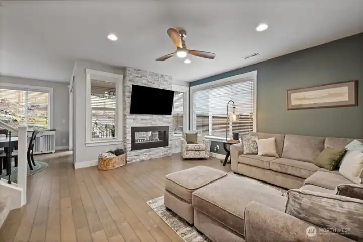 Light and welcoming great room with ceiling fan, gas fireplace and views to the backyard