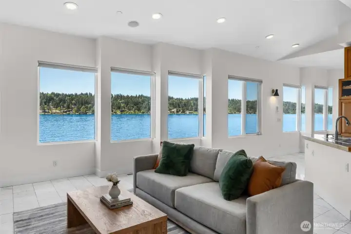 Waterfront views take center stage in this living room where oversized windows create a stunning backdrop for everyday living. Designed to maximize the setting, this space offers uninterrupted sightlines to the water from the comfort of your sofa.