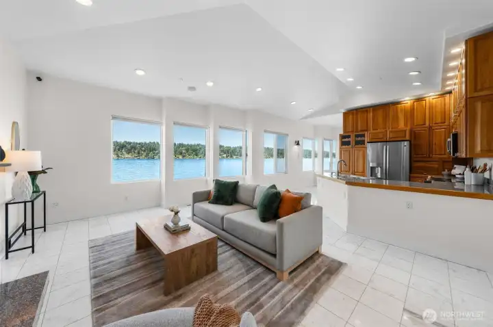The open-concept living area seamlessly connects the living room and kitchen while maximizing waterfront views from nearly every angle.