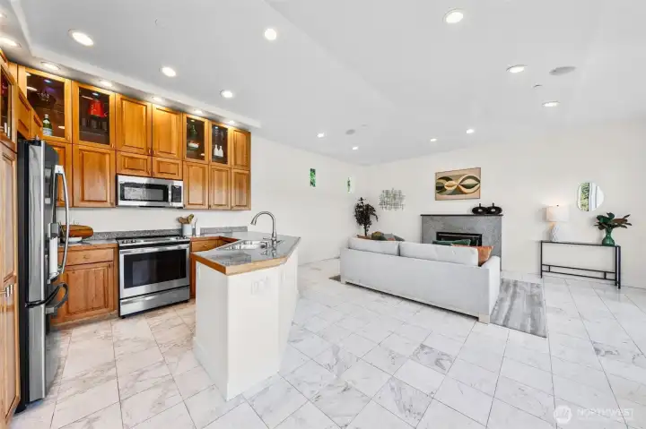 Designed for seamless entertaining, the kitchen opens directly to the living area with soaring ceilings, marble tile flooring, and expansive spaces for gathering. Custom cabinetry, granite surfaces, and open sightlines create a layout that connects cooking, dining, and waterfront living.