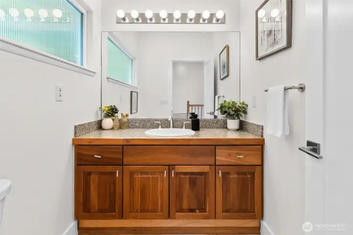 Conveniently located on the second level, this powder room features granite countertops, wood cabinetry, and clean finishes that complement the surrounding living spaces. Positioned near the main living areas, it offers both convenience and style for everyday living and entertaining.