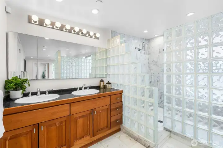 Designed with both style and function in mind, the Primary Bathroom features a dual vanity, extensive counter space, granite finishes, and striking architectural glass block details. A layout built for everyday convenience while creating a true retreat experience.