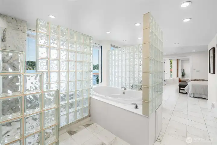 The Primary Bath makes a statement with dramatic glass block walls, marble finishes, and a layout designed around the waterfront setting. Centered around a jetted soaking tub and surrounded by architectural details, this space delivers a true spa-inspired experience.