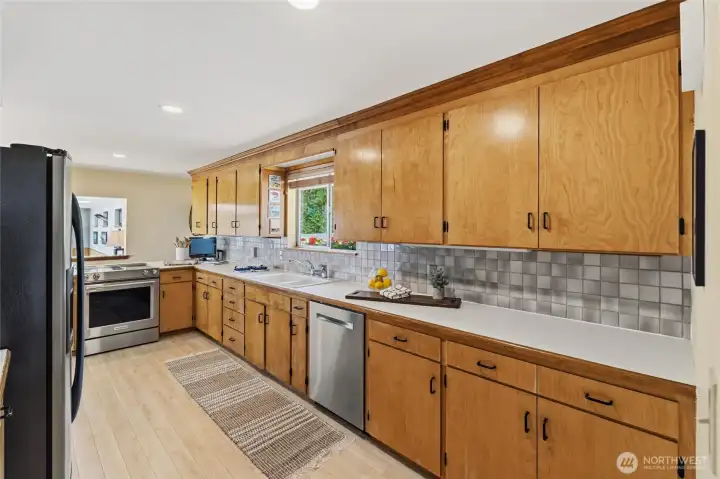 Bright kitchen with abundant cabinetry, generous counter space, and a large window overlooking the front yard. Bright kitchen with abundant cabinetry, generous counter space, and a large window overlooking the front yard.