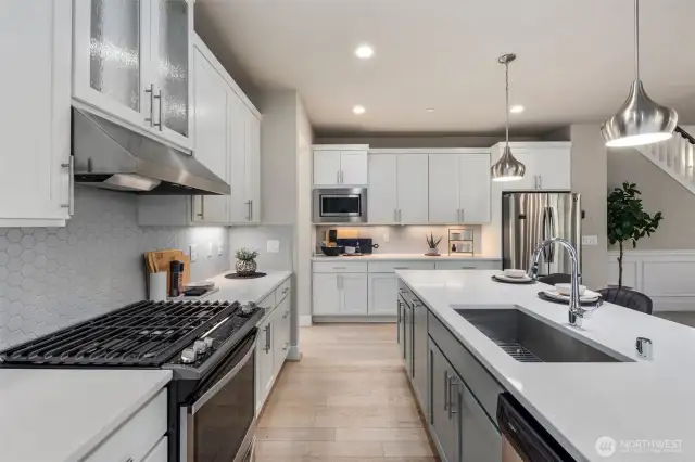 This is a chefs dream kitchen with gas stoves an oversized Island for eating and entertaining plenty of storage space and easy backyard access for your spring and summer gatherings.