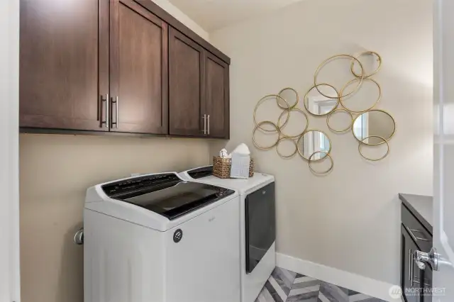 Large laundry room with plenty of storage space and countertop.Designer tile floors as well.