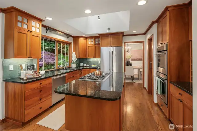 Epicurean kitchen with 5-burner gas cooktop, double ovens, walk-in pantry and stone countertops with slate backsplash accents