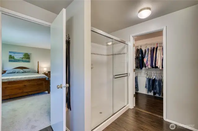 Shower with tile surround and glass door and large walk in closet.
