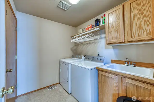 Laundry room with deep sink and additional cabinets.