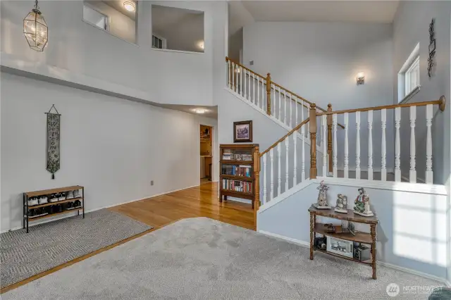 Living room has high vaulted ceilings, lots of light with a glimpse up to the landing above.