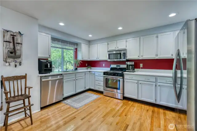 Kitchen boasts newer stainless appliances, corrian counter tops with undermount sink and beautiful hardwood floors.