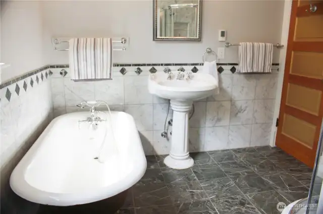4 piece bathroom with clawfoot tub and marble tile