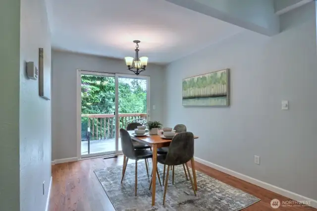 The dining area is adjacent to the kitchen and opens to the deck overlooking the backyard.